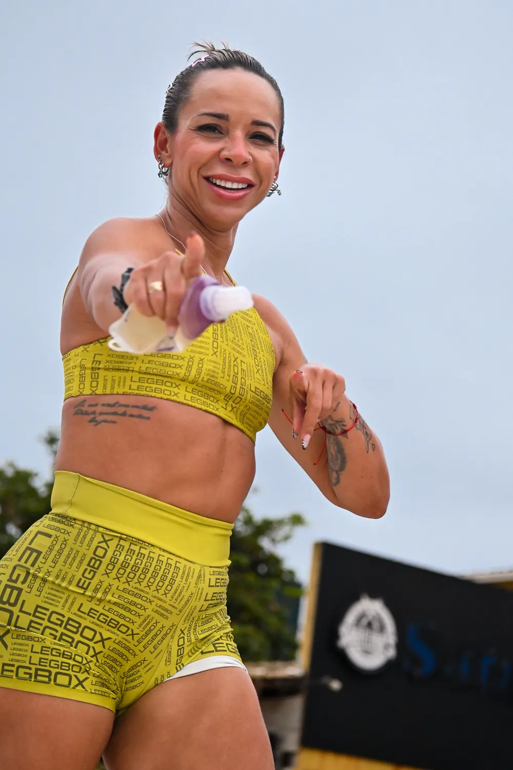 Atleta sorrindo e apontando para a câmera